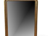 un miroir à cadre doré posé sur une surface blanche, avec un fond blanc