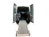 a white van with its door open and a ramp attached to it