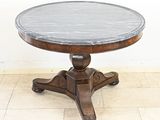 une photo d'une table ronde au plateau en marbre posée sur un piètement en bois