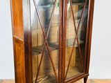 an image of a wooden cabinet with glass doors on a wooden floor