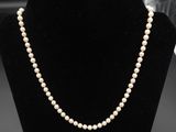 un collier de perles blanches sur un mannequin noir