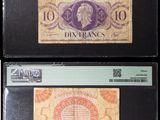 Quatre types différents de billets de banque sont exposés dans une vitrine noire