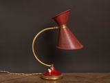 une photo d'une lampe de table rouge posée sur une table en bois