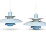 two blue and white lamps hanging from the ceiling on a white background