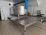 une grande table en acier inoxydable au milieu d'une cuisine