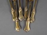 four silverware spoons and a fork on a gray surface