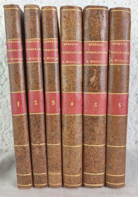 six old books are lined up on a shelf