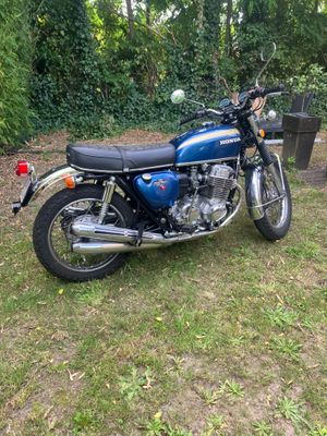 une moto garée dans l'herbe près des arbres
