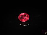 a close up of a red diamond on a black surface