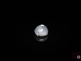 gros plan d'un diamant blanc sur une surface noire