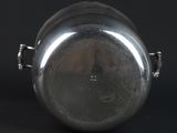 an old silver pot with a handle on a black background