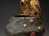 un oiseau perché sur un vase posé sur une table