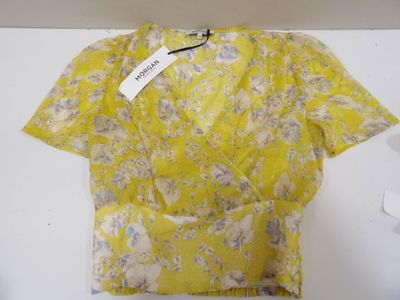 Le t-shirt est jaune et blanc, avec un motif floral.