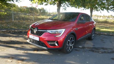 La voiture rouge est garée sur le bord de la route.