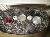 a marble table with three cups and a saucer on it