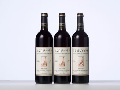 trois bouteilles de vin rouge posées sur une table