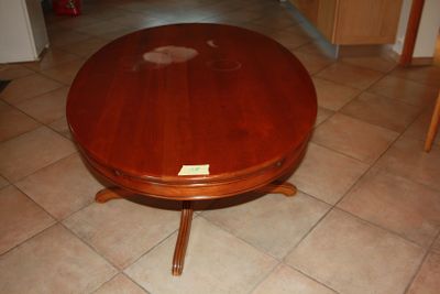 a wooden table with a glass top on a tile floor