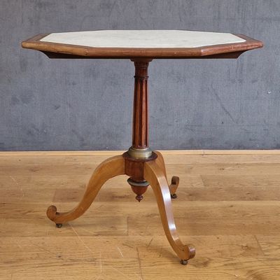 une petite table avec un plateau en marbre posé sur un piètement en bois