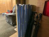a lot of baseball bats that are leaning against a wall