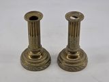pair of antique brass candlesticks on a white background