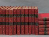 six red books stacked on top of each other on a table