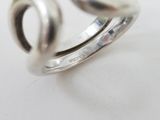 pair of silver rings sitting on top of each other on a white surface