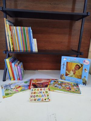 de nombreux livres pour enfants posés sur une table, avec une bibliothèque en arrière-plan
