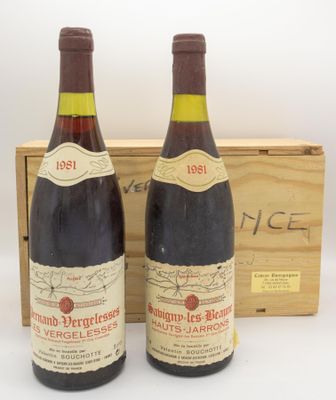 deux bouteilles de vin rouge sont posées devant une caisse en bois