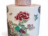 a jar with a lid that has flowers and birds on it