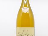 the bottle of white wine is sitting on a white surface