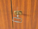 a close up of a door handle on a wooden cabinet