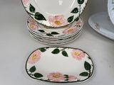 a stack of plates with pink flowers on them on a table
