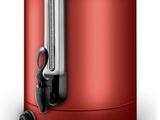 the red electric kettle is sitting on a white surface