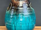 a blue vase that is sitting on a wooden table