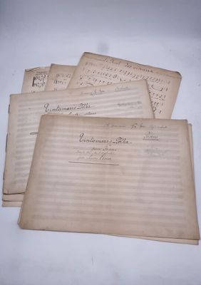 quatre feuilles de papier à musique usagé posées sur une table