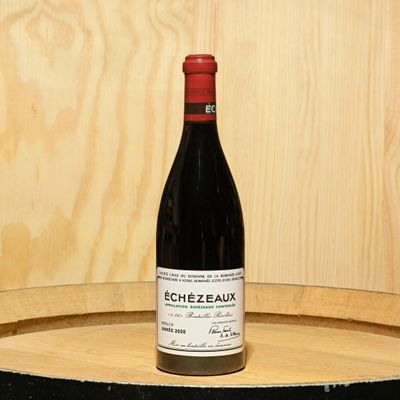 a bottle of wine sitting on top of a barrel