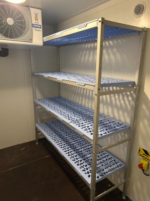 un rayonnage métallique muni d'étagères et d'un ventilateur dans une pièce