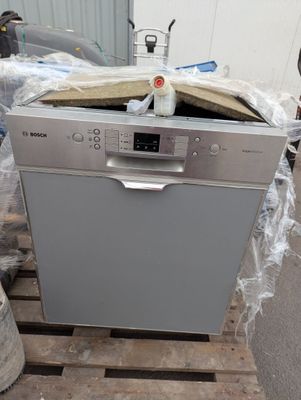 un lave-vaisselle posé sur une palette dans un entrepôt