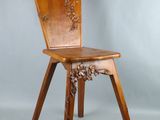 une image représentant une chaise en bois dont le dossier et l'assise sont sculptés