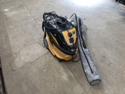 un aspirateur jaune et noir posé par terre dans un garage