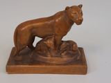 statue of a lion and a dog on a base on a white surface