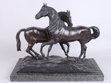 statue en bronze représentant deux chevaux au galop, posée sur un socle en marbre