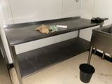 une table en métal sur laquelle se trouve une poubelle
