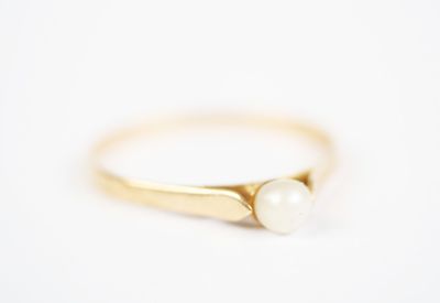 a gold ring with two pearls on top of it