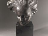 a close up of a sculpture of a woman ' s head on a black base