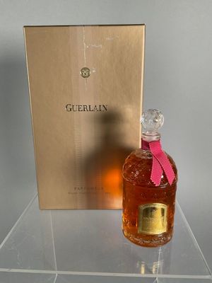 a bottle of guerlain on a clear table