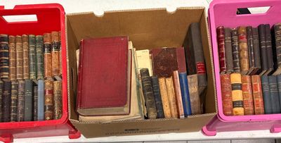three boxes of books are stacked on a shelf in a room
