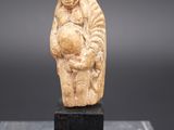 une vieille figurine sculptée représentant un homme tenant un enfant dans ses bras