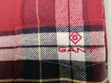 the back of a red and black plaid shirt with a white logo on it