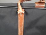 a black suitcase with a brown handle and a brown handle